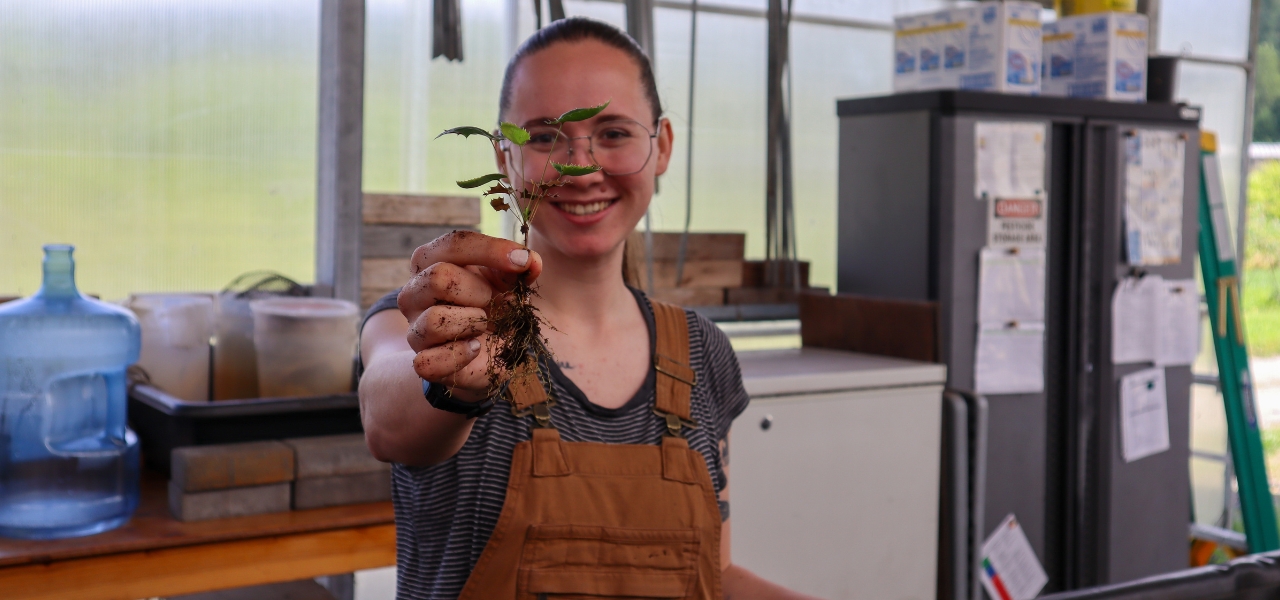 Lea Dyga holding a native plant seedling at Oxbow’s Native Plant Nursery.