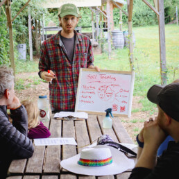Instructor teaching soil testing basics with a whiteboard during a garden education workshop.