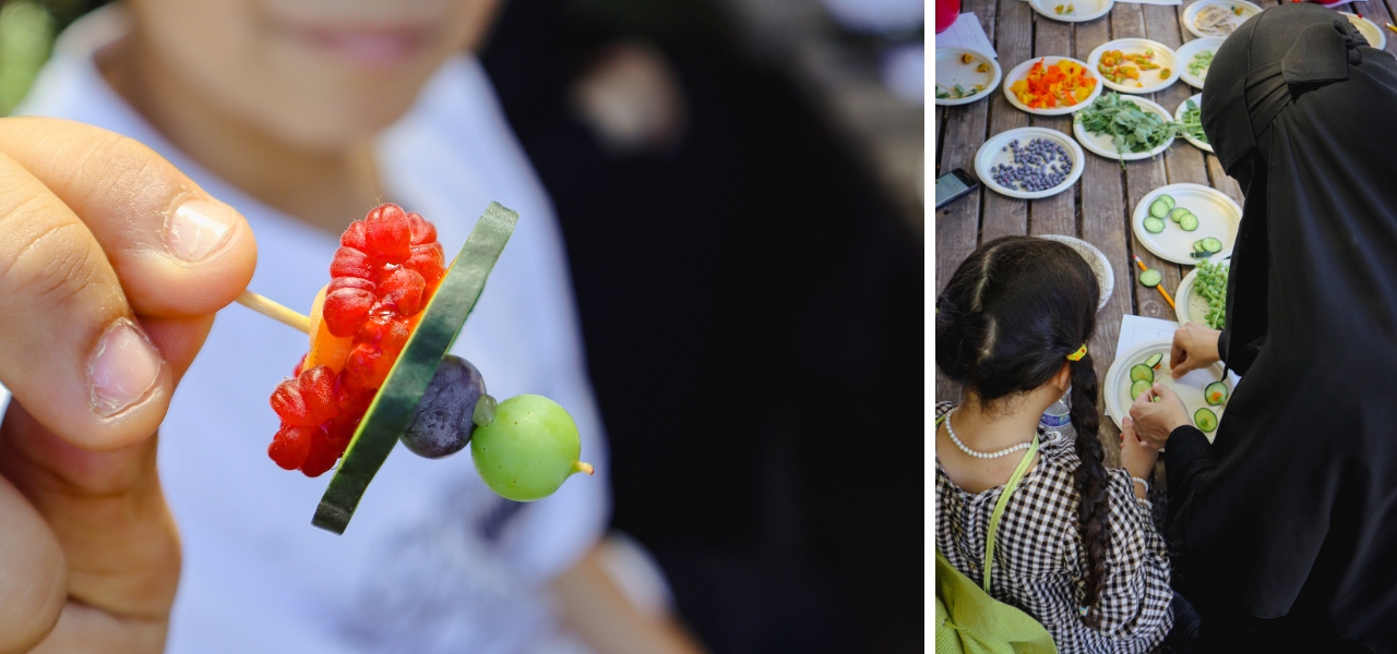 Child and adult explore fresh ingredients together at a culinary workshop table.