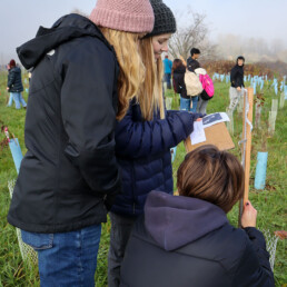 Teen students taking notes during a restoration field study.