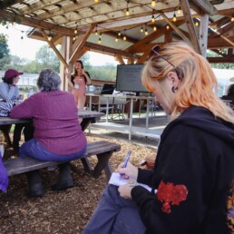 Participants attending a native plant seed workshop and taking notes during an outdoor class at Oxbow.