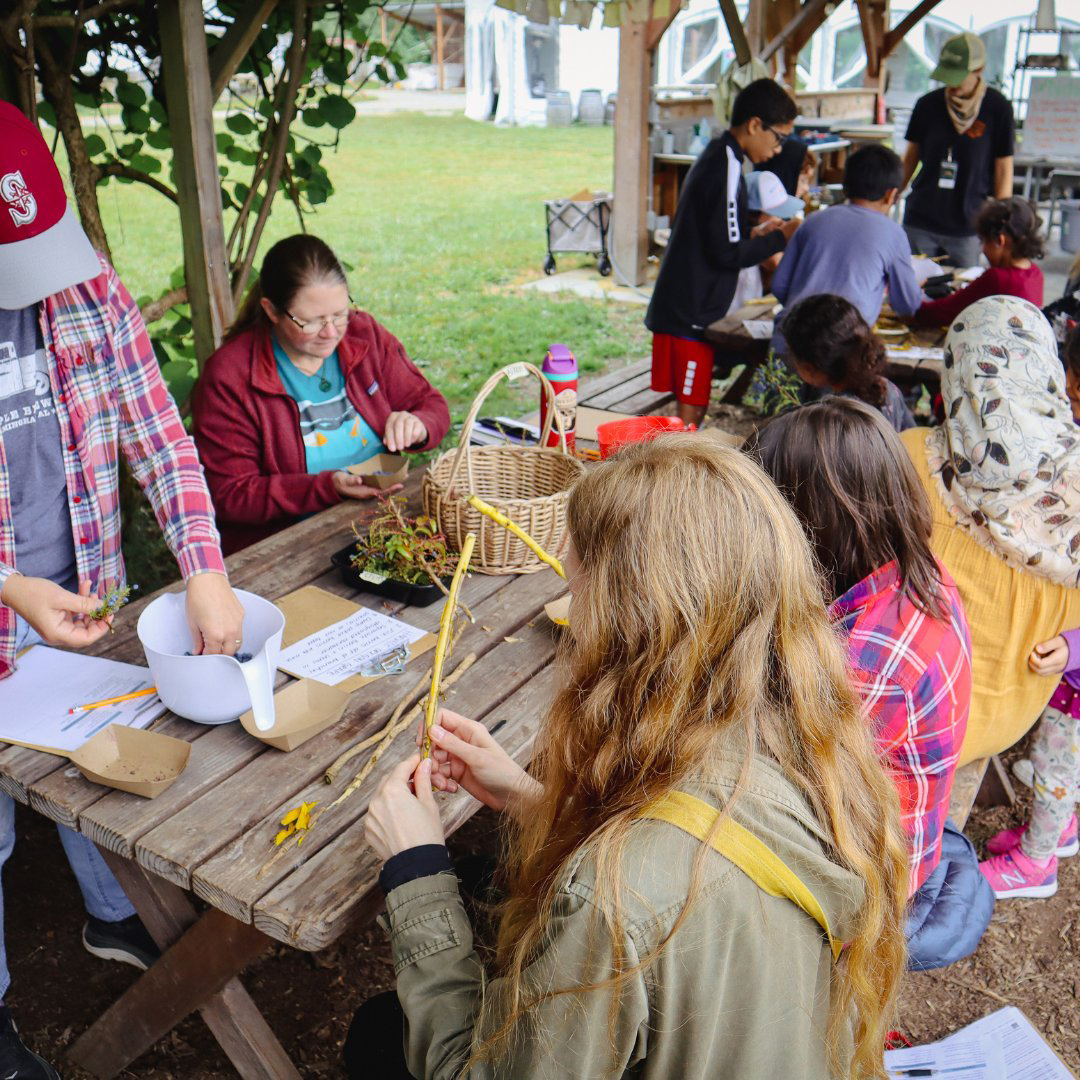 Families creating nature crafts together during a hands-on activity at Oxbow.