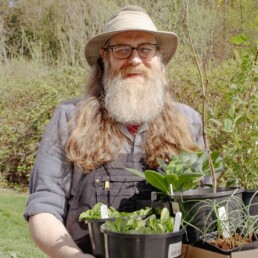 Visitor holding a tray of native plants purchased at the Oxbow Spring Native Plant Festival.
