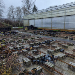 Empty plant pots scattered across nursery tables after flooding